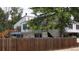 Apartment building with wood fence, lush trees, balcony and blue trim at 12120 Melody Dr # 308, Westminster, CO 80234