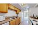 Efficient kitchen space with wood cabinets, white appliances, and tile flooring leading to living room at 12120 Melody Dr # 308, Westminster, CO 80234