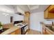 Compact kitchen featuring essential appliances, wood cabinets, and an opening to other rooms at 12120 Melody Dr # 308, Westminster, CO 80234