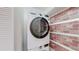 Convenient in-unit laundry with stackable LG washer and dryer set against a stylish brick accent wall at 12120 Melody Dr # 308, Westminster, CO 80234