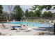 Community pool with lounge chairs surrounded by mature trees and green landscaping at 12120 Melody Dr # 308, Westminster, CO 80234
