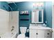 Bathroom features a toilet, vanity, mirror, and a shower with a white-tiled wall at 8864 S Field Ct, Littleton, CO 80128