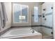 Bright bathroom with a shower, tub, and window at 8864 S Field Ct, Littleton, CO 80128