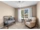 Bright bedroom features a crib, chair, and a large window offering plenty of natural light at 8864 S Field Ct, Littleton, CO 80128