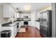 Bright kitchen features white cabinets, stainless steel appliances, and hardwood floors at 8864 S Field Ct, Littleton, CO 80128