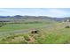 Scenic view of rolling hills and a winding road from a grassy hilltop with a bench at 8864 S Field Ct, Littleton, CO 80128