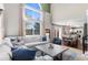 Open-concept living room with high ceilings flowing into the dining area with backyard views at 8864 S Field Ct, Littleton, CO 80128
