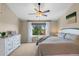 Main bedroom with ceiling fan, soft lighting, and a window overlooking trees at 8864 S Field Ct, Littleton, CO 80128