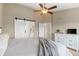 Comfortable main bedroom with a ceiling fan, white dresser and sliding barn door to bathroom at 8864 S Field Ct, Littleton, CO 80128
