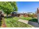 Spacious backyard with green lawn, convenient parking, and a charming brick house at 2564 S Acoma St, Denver, CO 80223