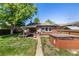 Cozy brick house backyard featuring a relaxing covered patio and a soothing hot tub at 2564 S Acoma St, Denver, CO 80223