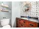 Charming bathroom featuring a decorative mirror and floral wallpaper at 2564 S Acoma St, Denver, CO 80223