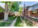 Backyard driveway next to brick home with covered patio, perfect for private parking at 2564 S Acoma St, Denver, CO 80223