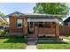 Charming brick home with a cozy covered porch featuring stylish awnings at 2564 S Acoma St, Denver, CO 80223