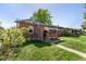 Quaint brick home with a covered porch, landscaped yard, and inviting curb appeal at 2564 S Acoma St, Denver, CO 80223