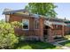 Charming brick home with a covered porch, flag, and beautiful landscaping at 2564 S Acoma St, Denver, CO 80223
