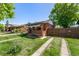 Brick home with covered porch and a driveway, perfect for suburban living at 2564 S Acoma St, Denver, CO 80223