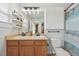 Bright bathroom with a double sink vanity, white cabinets, shelving, and a shower/tub combination at 18173 E Saskatoon Pl, Parker, CO 80134