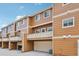 Exterior view of tan townhomes with garages and second-story balconies at 18173 E Saskatoon Pl, Parker, CO 80134