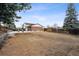 Large backyard featuring a stone retaining wall, mature trees, a basketball hoop, and wooden fences at 7488 S Lafayette E Cir, Centennial, CO 80122