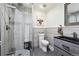 Modern bathroom featuring a glass shower, pebble flooring, and dark wood vanity with stylish mirror at 7488 S Lafayette E Cir, Centennial, CO 80122