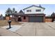 Charming two-story home featuring a brick exterior, a large driveway, and a manicured front lawn at 7488 S Lafayette E Cir, Centennial, CO 80122