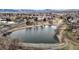 A captivating aerial view of a serene lake surrounded by a charming neighborhood with mountain views at 1823 S Carr St, Lakewood, CO 80232