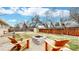 Backyard includes wood fence, green grass, and stone firepit area surrounded by wood chairs at 1823 S Carr St, Lakewood, CO 80232