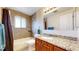 Well-lit bathroom with granite countertop, tile flooring, and shower over tub at 1823 S Carr St, Lakewood, CO 80232