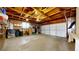 Spacious two-car garage with white doors, wooden ceiling supports, and concrete flooring at 1823 S Carr St, Lakewood, CO 80232