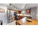Well-lit kitchen with stainless steel appliances, warm wood cabinetry, and a breakfast nook area at 1823 S Carr St, Lakewood, CO 80232