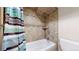 Tiled shower and tub combination with chrome shower head and soap/shampoo shelf at 1823 S Carr St, Lakewood, CO 80232