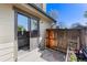 Back patio with sliding glass door, flower bed and wood fence at 10836 W Evans Ave # 29, Lakewood, CO 80227