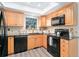 Efficient kitchen features wood cabinets, black appliances, and ample counter space at 10836 W Evans Ave # 29, Lakewood, CO 80227