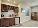 Basement wet bar features dark cabinets, a mini fridge, a stone backsplash, and space to create your favorite cocktails at 2033 E 167Th Way, Thornton, CO 80602