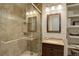Updated bathroom featuring a glass-enclosed shower with tile surround, a modern vanity, and functional storage at 2033 E 167Th Way, Thornton, CO 80602