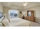 Bright bedroom features tray ceiling, large window, and dresser with mirror at 2033 E 167Th Way, Thornton, CO 80602