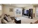 Inviting living room with plush seating, neutral carpet, and entertainment center at 2033 E 167Th Way, Thornton, CO 80602