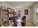 A cozy office space with built-in shelving, a dark wood desk, and a comfortable chair at 2033 E 167Th Way, Thornton, CO 80602