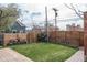 Landscaped backyard with wooden fence, green lawn, wood pile, and brick accents create a private outdoor oasis at 131 N Sherman St, Denver, CO 80203