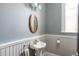 Bathroom featuring a pedestal sink, wainscoting, an oval mirror, and a neutral color scheme at 131 N Sherman St, Denver, CO 80203
