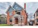 Stunning brick Victorian home with a covered porch, detailed trim, and classic architectural elements at 131 N Sherman St, Denver, CO 80203