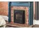 Elegant fireplace with decorative blue mantle and floral tile surround as an accent to the red brick wall at 131 N Sherman St, Denver, CO 80203