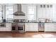 Modern kitchen with stainless steel appliances, white cabinets, marble backsplash, and hardwood floors at 131 N Sherman St, Denver, CO 80203
