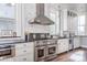 Updated kitchen with stainless steel appliances, white cabinets, marble backsplash, and hardwood floors at 131 N Sherman St, Denver, CO 80203