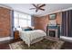 Main bedroom with exposed brick wall, decorative fireplace, and large window with curtains at 131 N Sherman St, Denver, CO 80203