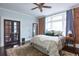 Main bedroom featuring a bed with a white comforter, exposed brick wall, and large window with curtains at 131 N Sherman St, Denver, CO 80203