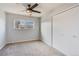 Cozy bedroom featuring a ceiling fan, neutral carpet, closet, and a bright window at 2314 S Troy St, Aurora, CO 80014