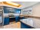 Charming kitchen featuring blue cabinetry, stainless steel appliances, and granite countertops at 2314 S Troy St, Aurora, CO 80014