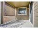 A covered patio featuring a retractable shade, a window, and access to the interior through a sliding glass door at 4238 S Netherland Cir, Aurora, CO 80013